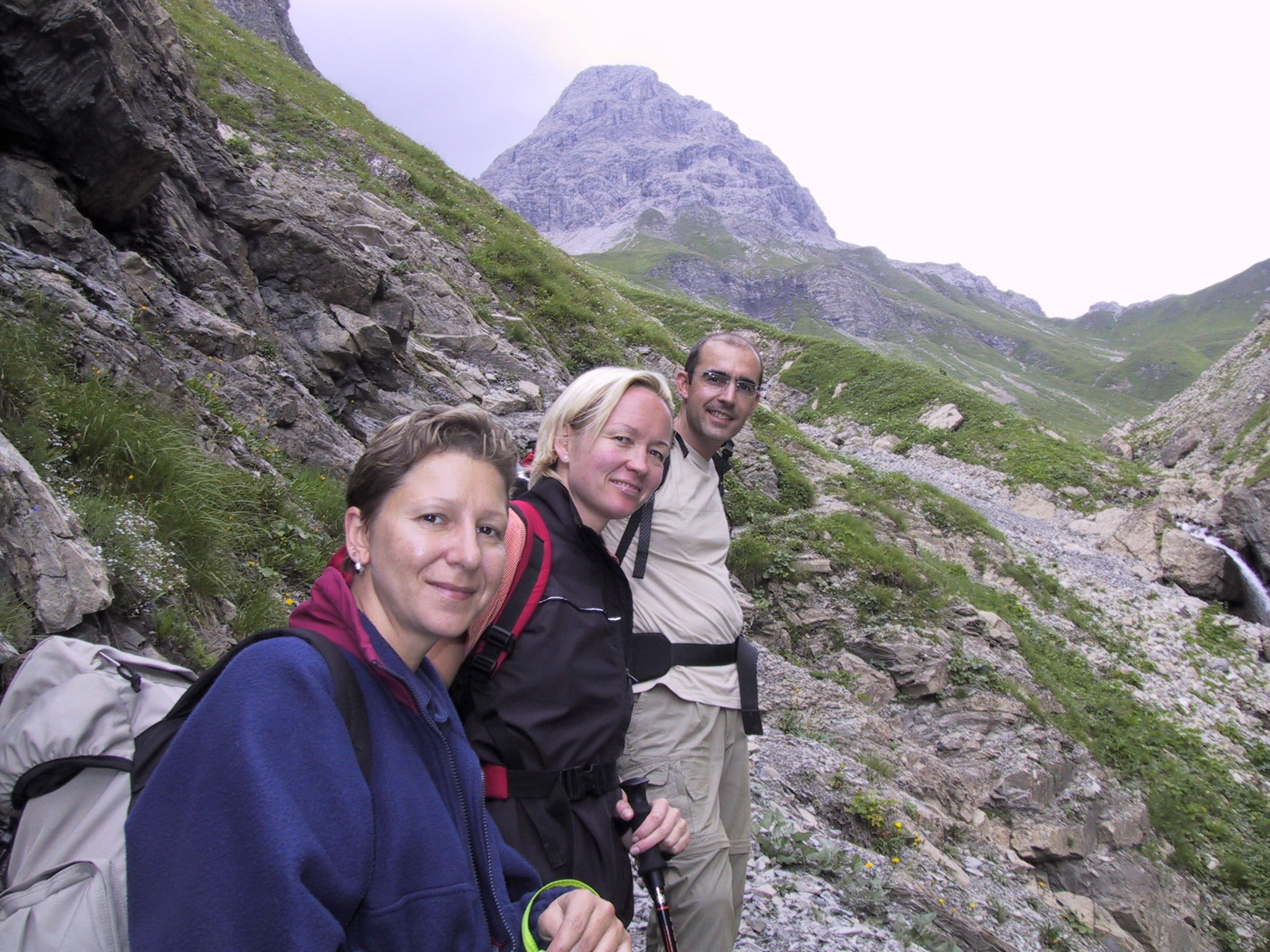 Drei Wandernde im Tal mit einem Allgäuer Berggipfel im Hintergrund