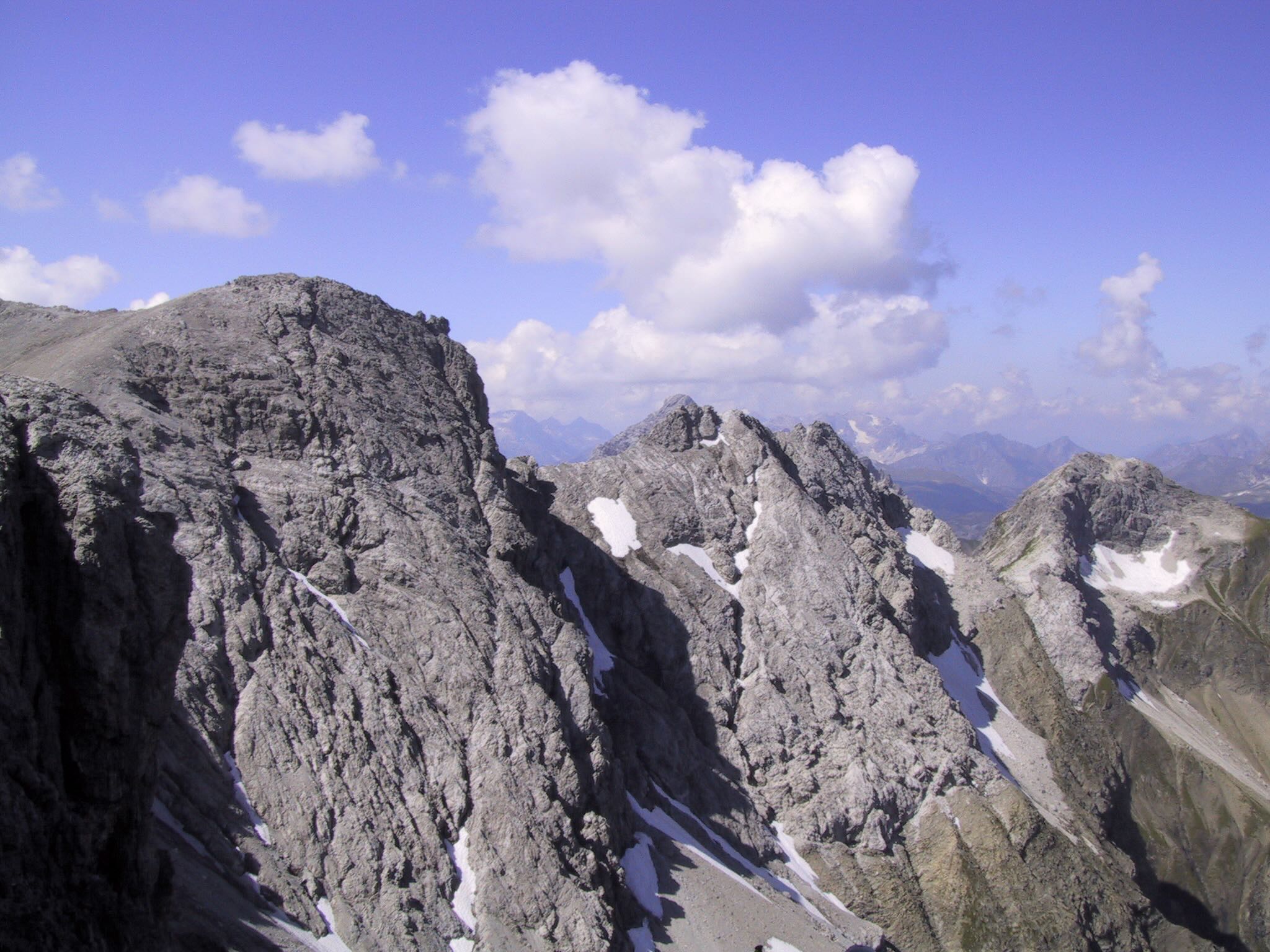 Felsiger Bergkamm mit Schneefeldern und Wolken am Heilbronner Weg